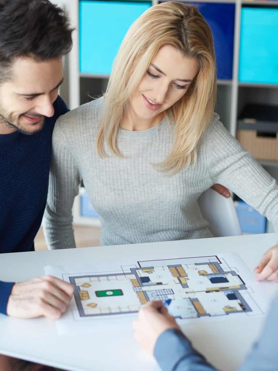 Persona revisando planos y presupuestos de su futura casa, simbolizando control y seguridad en la construcción de su hogar.